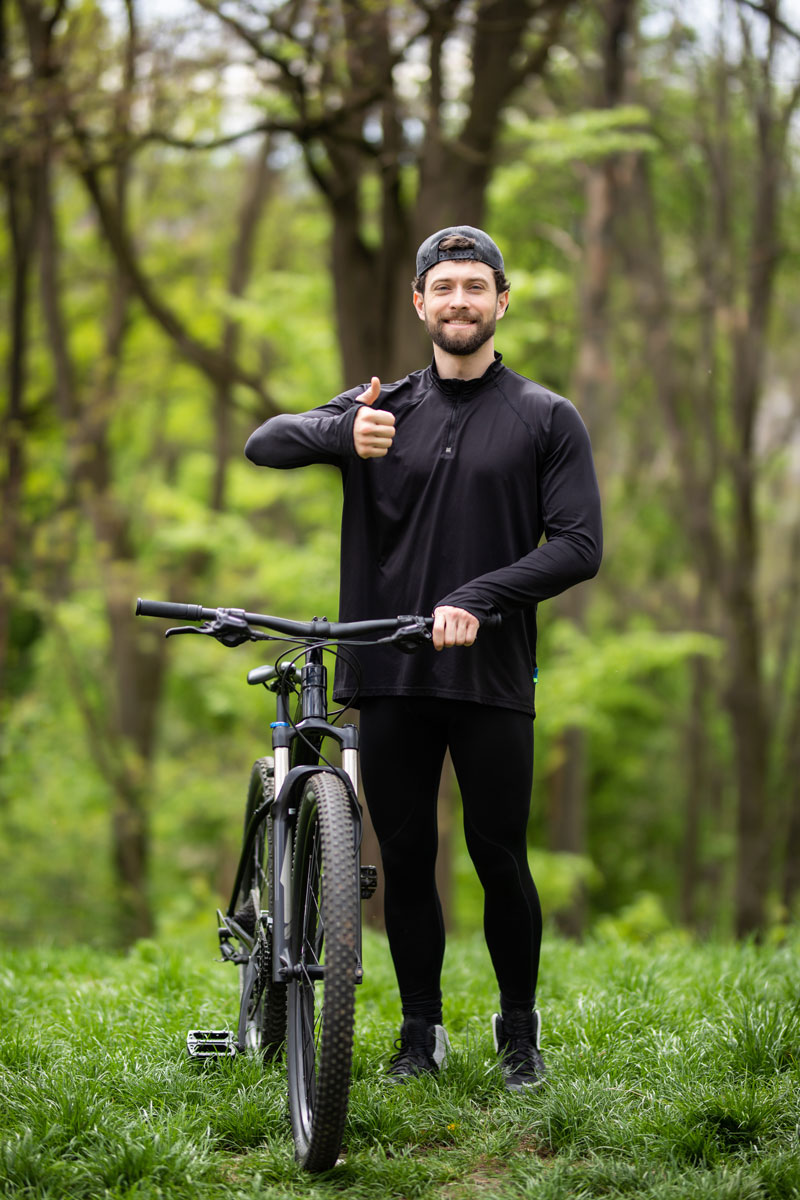 Confident and positive man in woods with bike